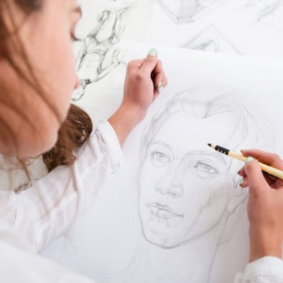 Artist sketching photorealistic face on paper