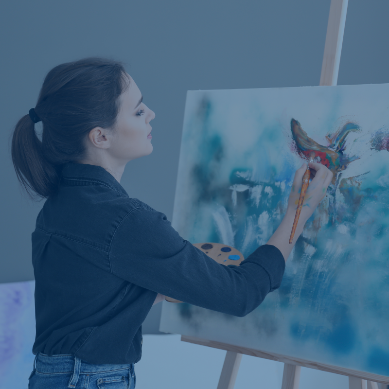 Picture of a woman painting a canvas.